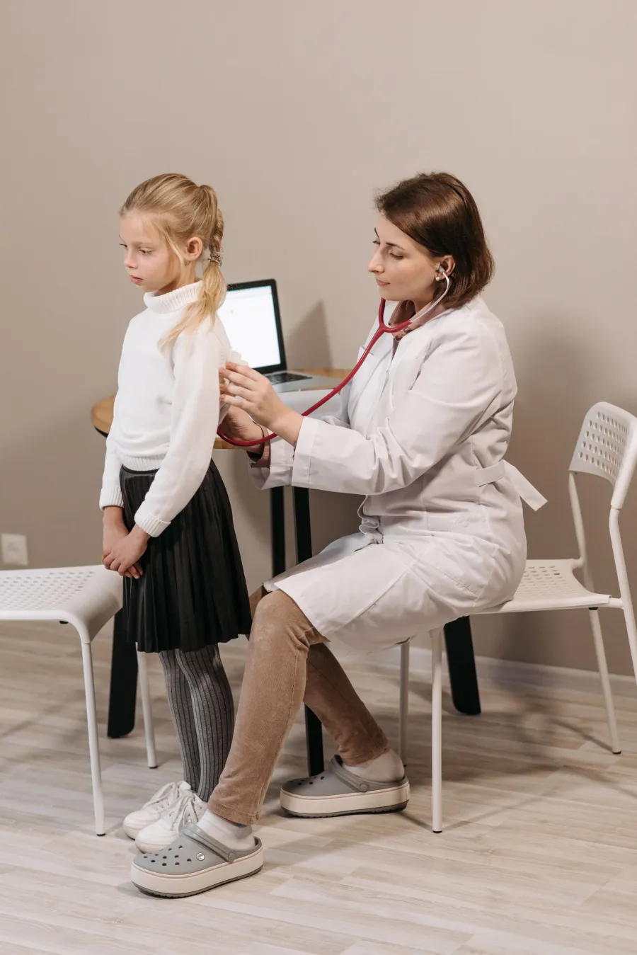 Pediatrician performing a wellness evaluation on a child