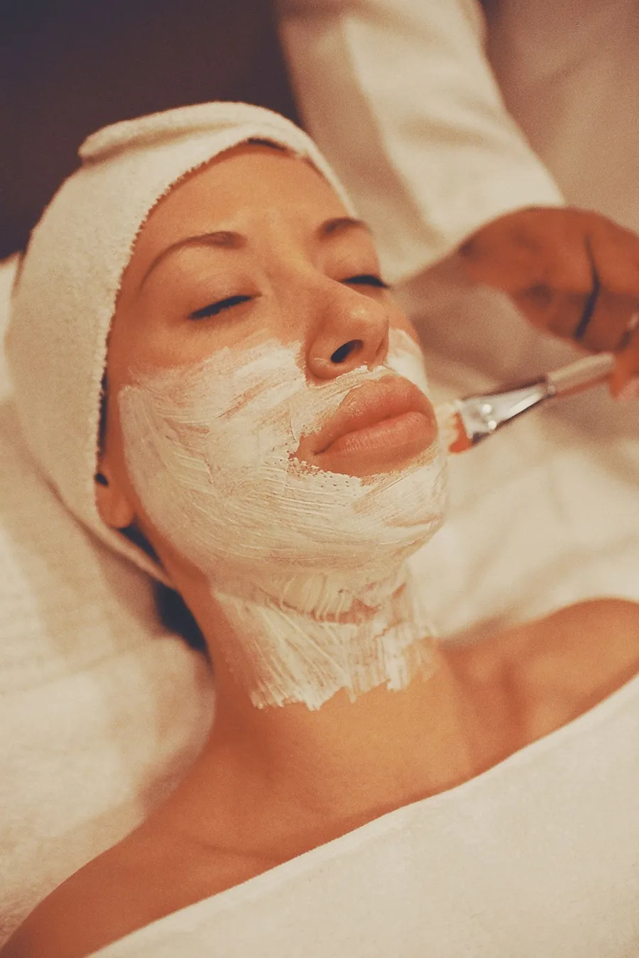 Woman receiving a facial treatment at a spa clinic, illustrative image