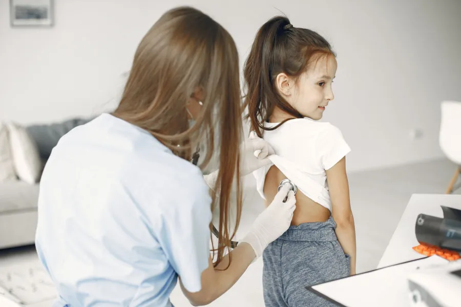 Doctor examining a young patient with a stethoscope