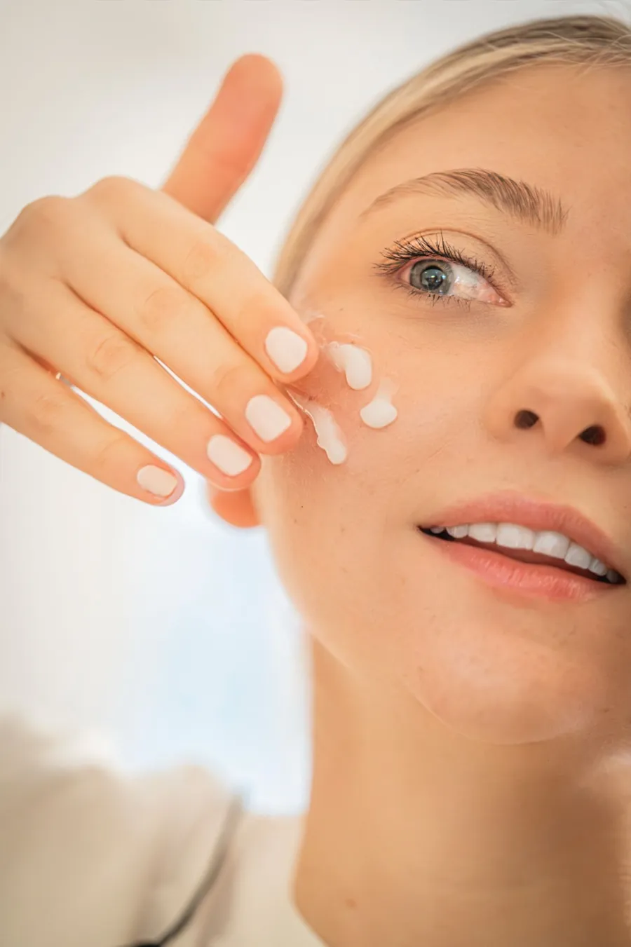 Close-up of a person applying skincare product to the face