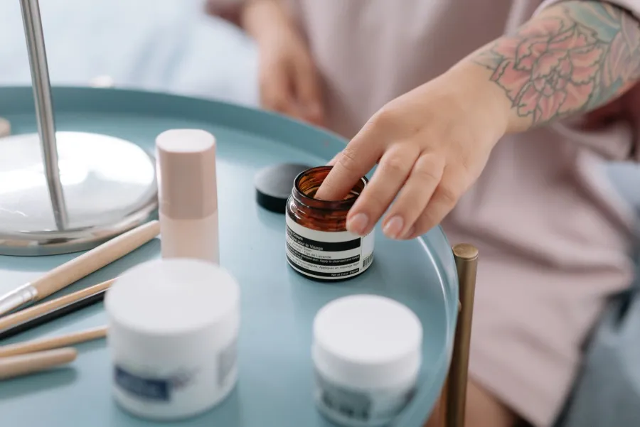 Hand reaching for skincare products, illustrative image