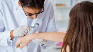 A doctor examining the patient's skin on the right hand