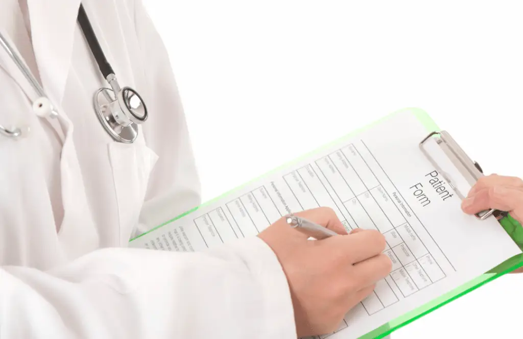 A close-up image of a doctor filling the patient's form