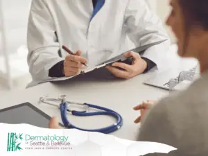 Doctor consulting with a patient at a dermatology clinic, with a stethoscope on the desk.