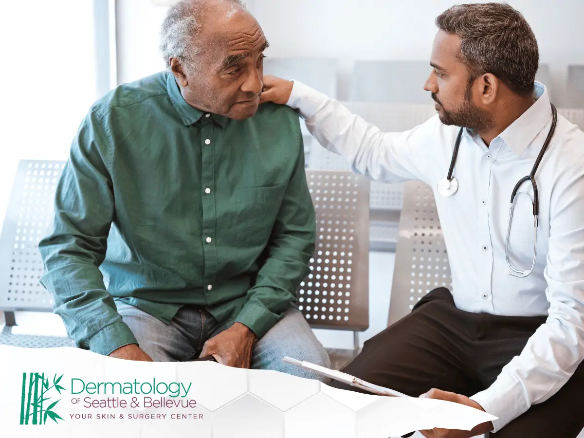 Doctor comforting an elderly patient during a consultation at a dermatology clinic.