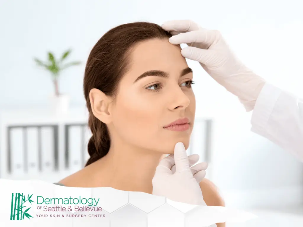 A professional assessing the facial skin of a young female patient in a clinical setting.