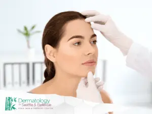 A professional assessing the facial skin of a young female patient in a clinical setting.