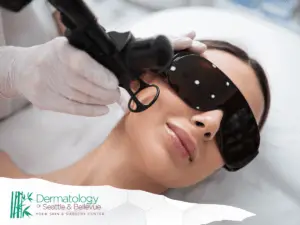 A woman undergoing a professional skin treatment with protective eyewear, as a gloved specialist uses advanced equipment on her face. The Dermatology of Seattle & Bellevue logo is displayed at the bottom.