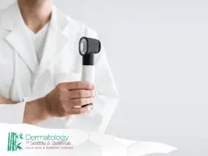 Doctor in white coat holding a handheld dermatoscope tool