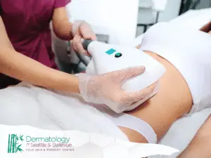 Clinician using handheld device on patient’s abdomen during treatment