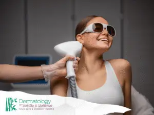 Woman wearing protective goggles receiving laser treatment on underarm.