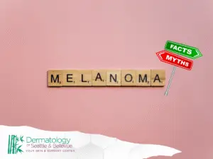 Scrabble tiles spelling “MELANOMA” on pink background with facts-myths sign