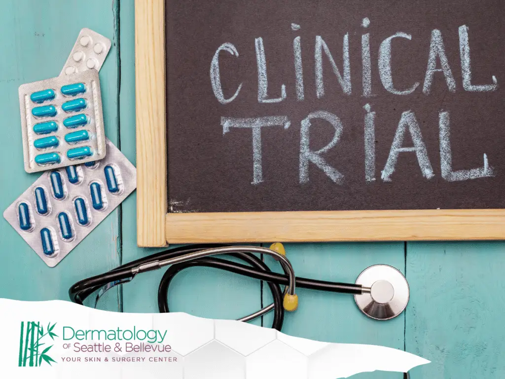 Chalkboard reading “CLINICAL TRIAL” with pills and stethoscope on teal surface