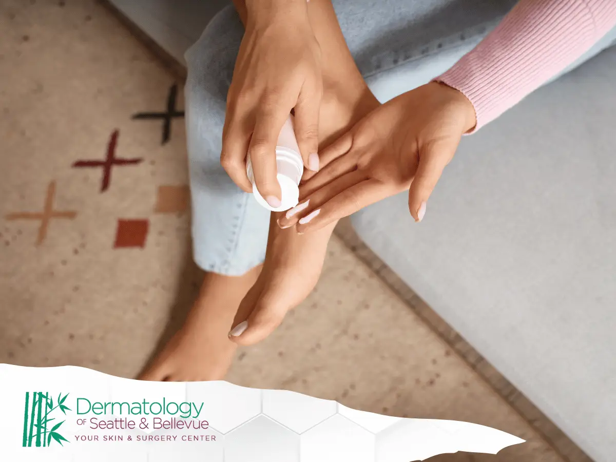Person applying cream to bare foot while sitting on couch