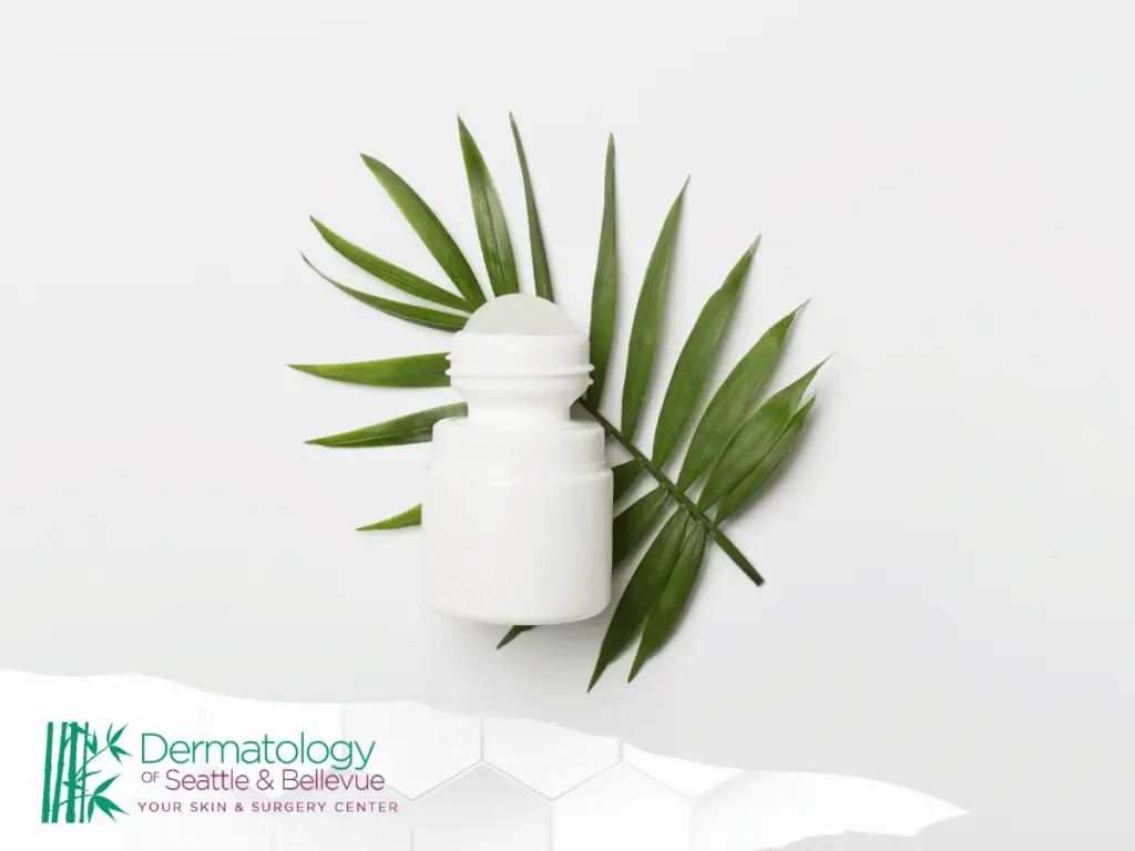White roll-on bottle on green palm leaves against white background