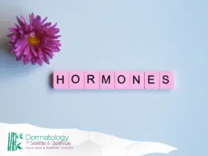 Pink flower and pink tiles spelling “HORMONES” on light blue background.