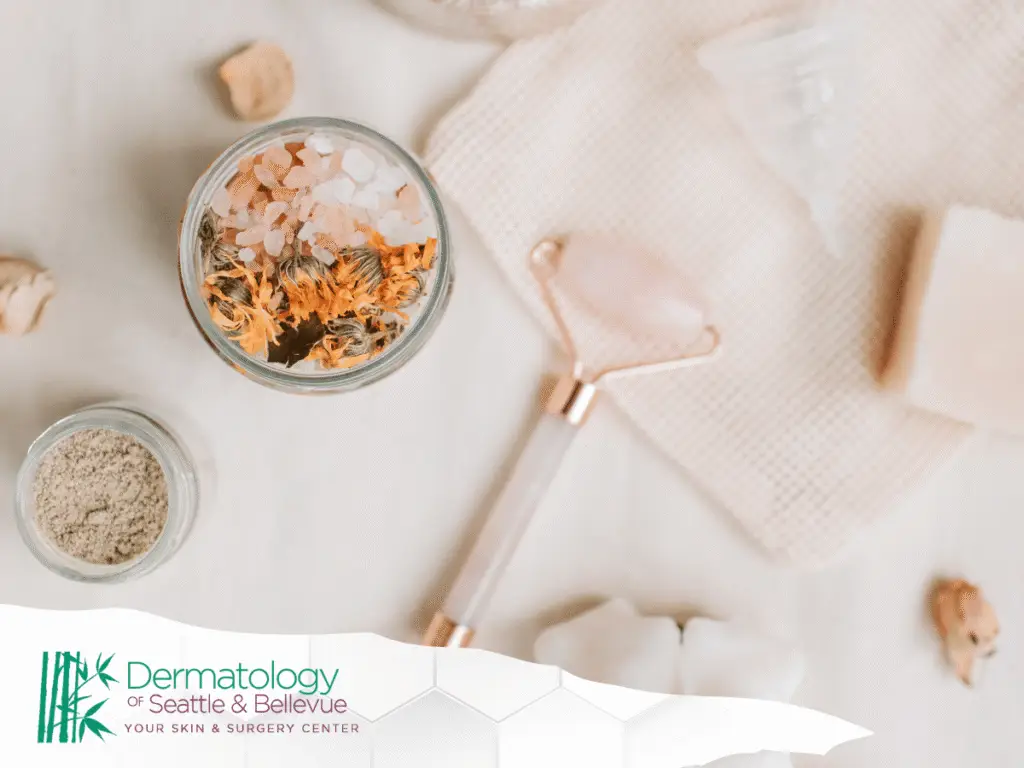 Flat lay of spa items including salt jar, face roller, soap.