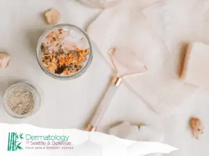 Flat lay of spa items including salt jar, face roller, soap.