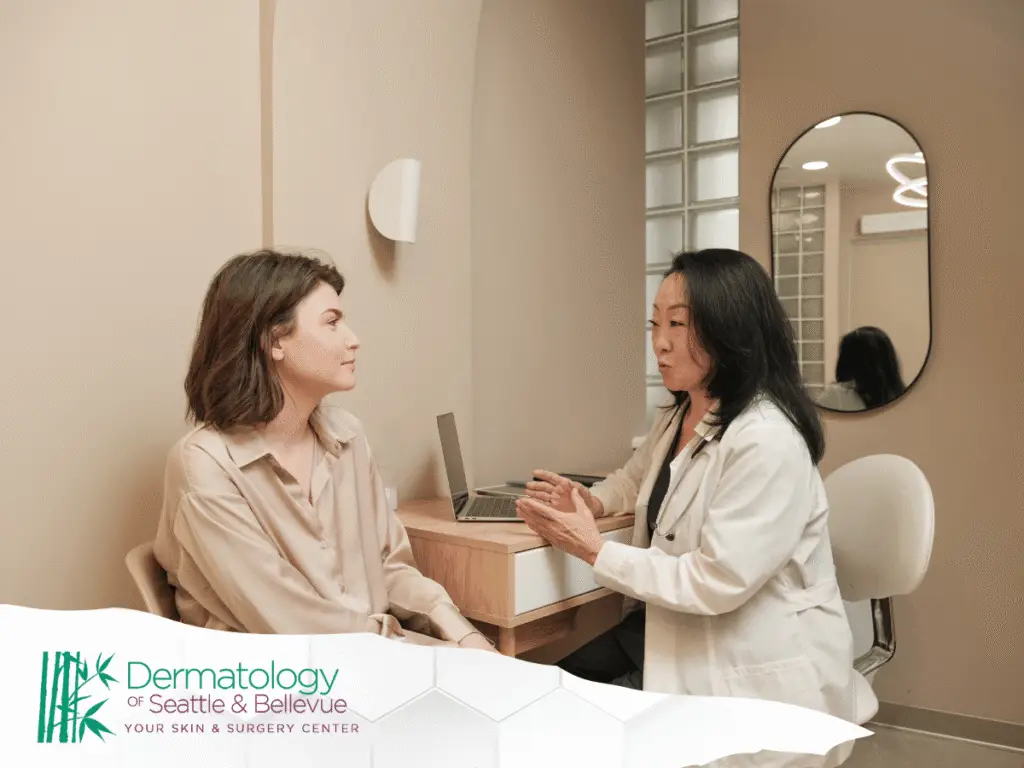 Dermatologist in white coat consulting with seated woman in beige blouse
