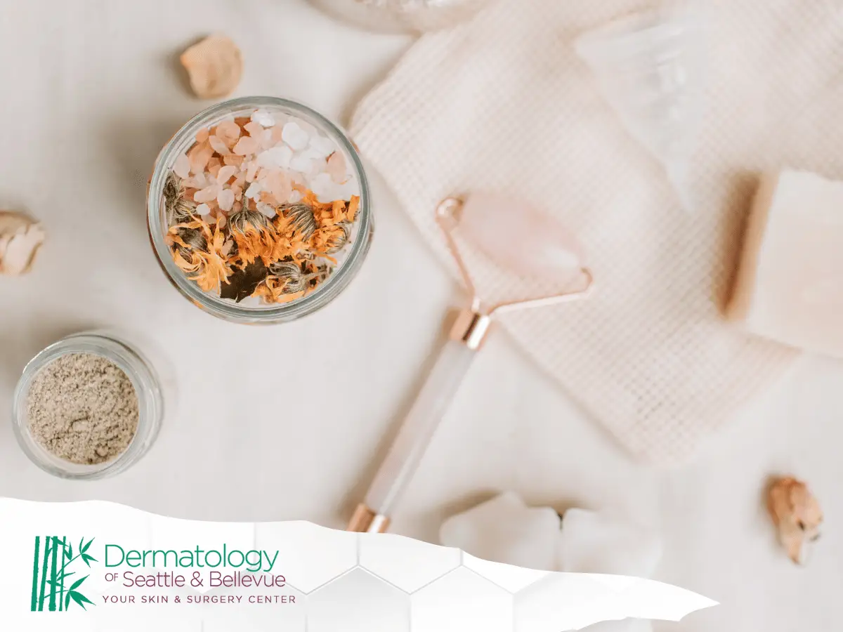 Flat lay of spa items including salt jar, face roller, soap.