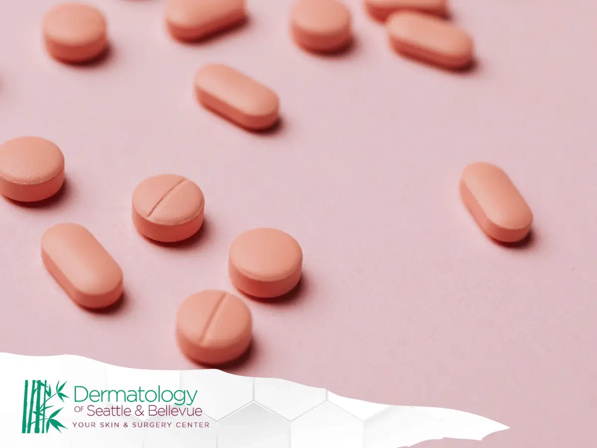 Pink tablets scattered on a pink surface, close-up view.