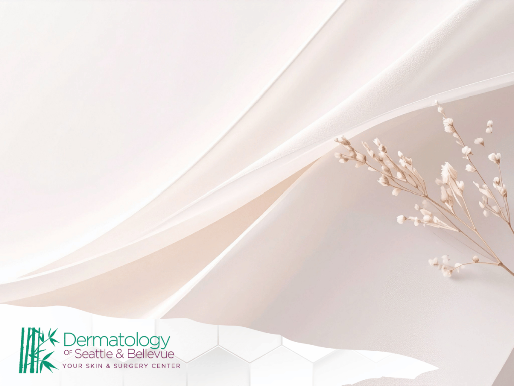 Soft pink fabric background with delicate white flower stems.