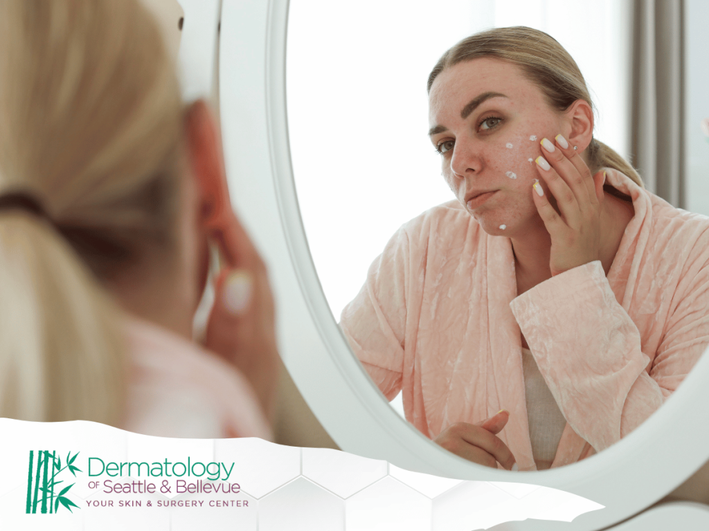 Woman applying skincare cream to her face in front of a mirror.