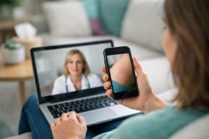 Patient shows skin on phone during video call with doctor